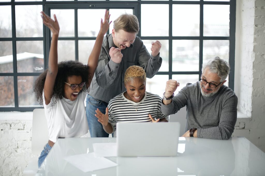 Excited recruiters happy about software solutions on laptop